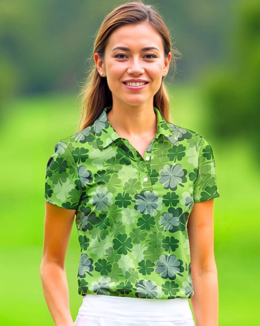 A woman smiles wearing a green golf polo with a clover pattern.