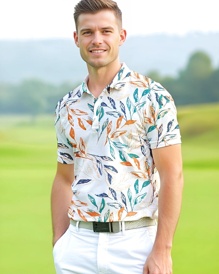 A man on a golf course wearing a colorful leaf pattern golf polo