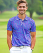 A man on a golf course wearing a purple geometric pattern golf polo