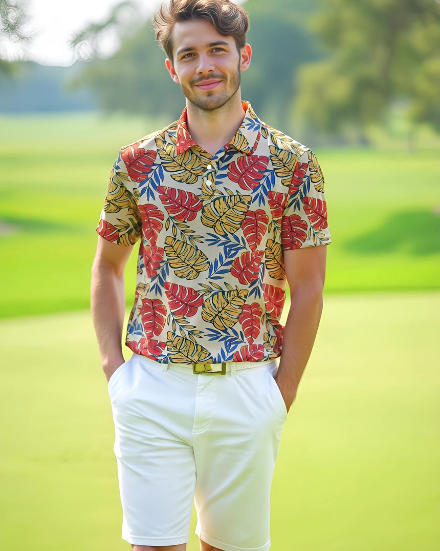 Man wearing a colorful leaf-patterned golf shirt and white shorts standing on a golf course.
