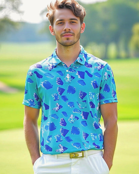A man on golf course wearing a golf polo shirt with a dark blue confetti shape print on light blue
