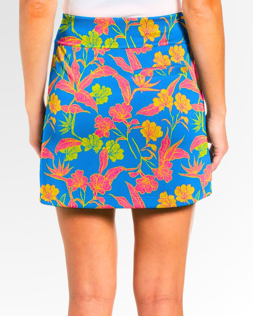 Close-up back view of a woman wearing a blue golf skort with a pink, yellow, and green floral pattern.