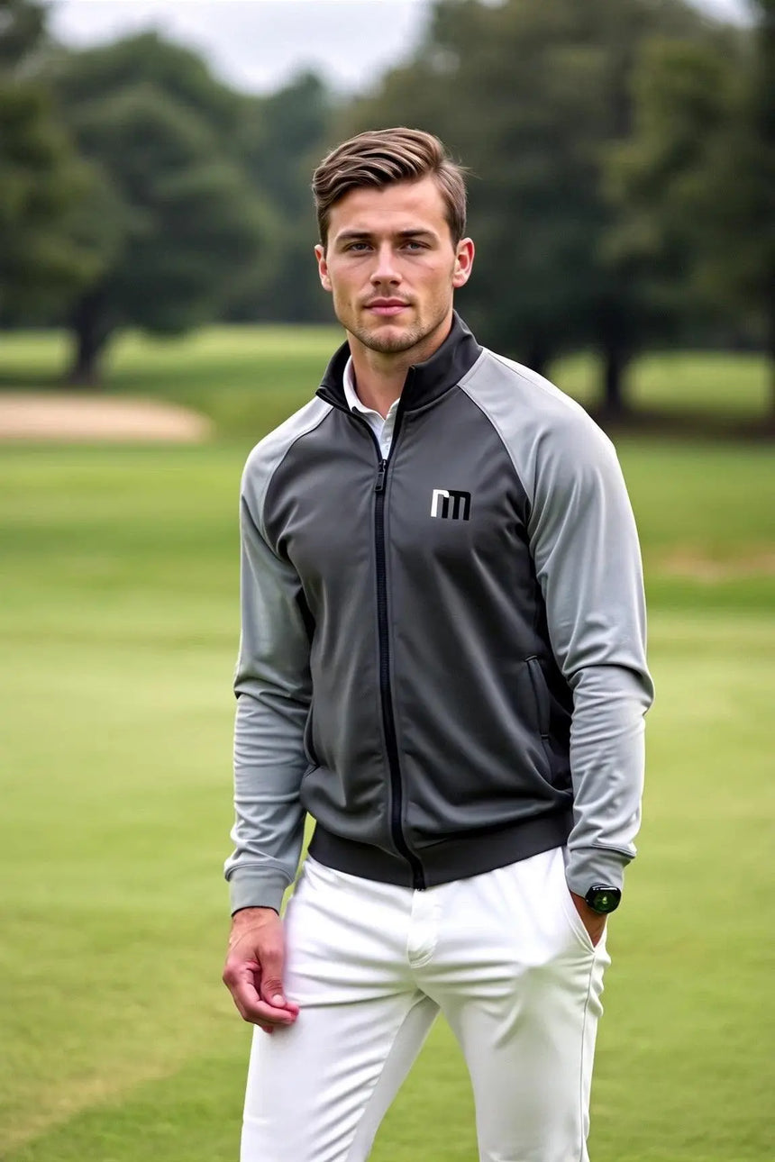 A man in golf attire stands on a golf course.