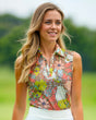 A woman smiles wearing a floral sleeveless golf polo.