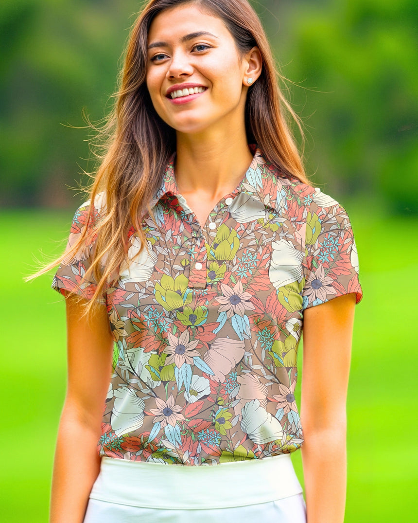 A woman smiles wearing a floral golf polo and white skirt.