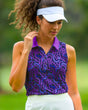 A woman wearing a sleeveless golf polo with a purple and blue swirl pattern and a white visor.