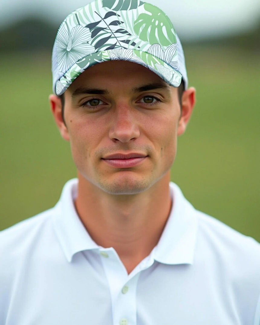 A close-up shot of a man wearing a white golf polo and a tropical print golf hat.