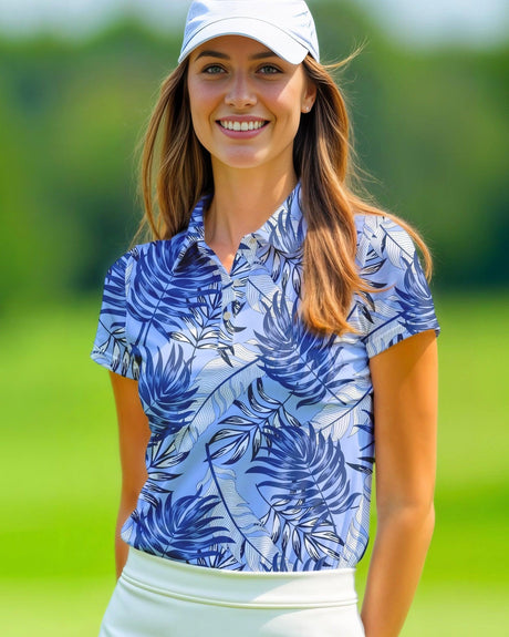 Woman wearing a blue leaf-patterned short sleeve golf shirt and white cap on a golf course