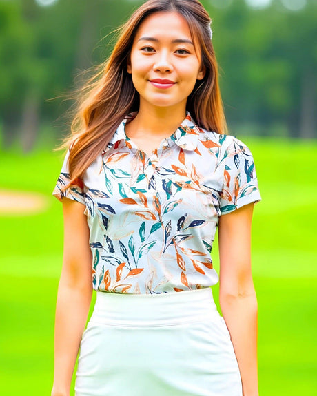 Woman wearing a floral polo shirt and white skirt standing on a golf course