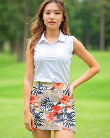 Woman wearing a white sleeveless top and floral skort outfit on a green outdoor background