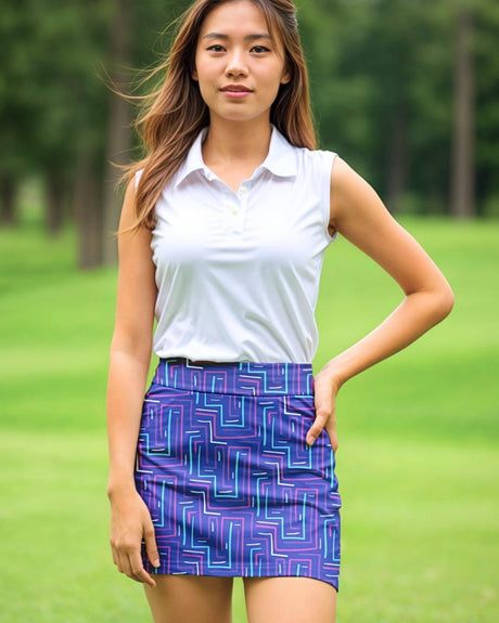 Woman wearing a white sleeveless top and purple patterned skirt on a golf course.