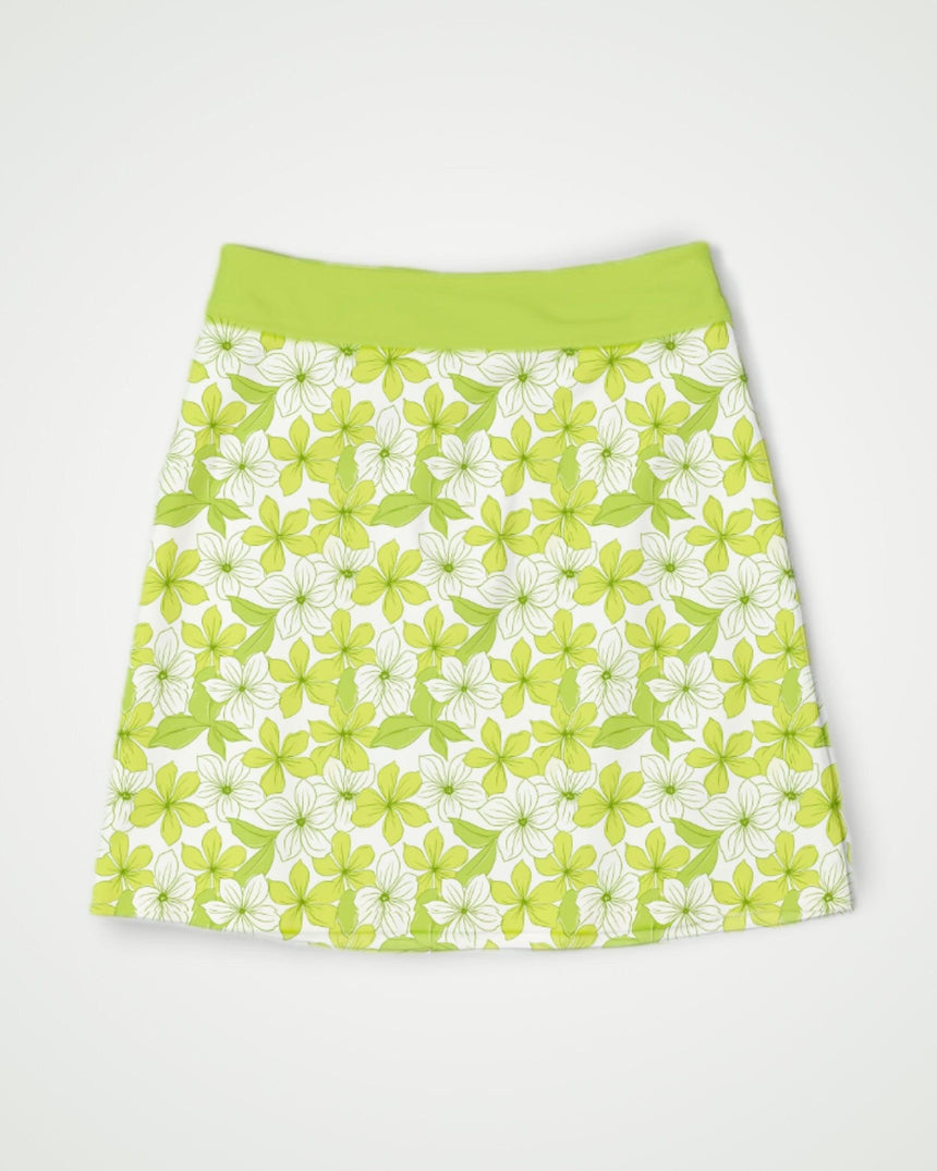 Green and white floral print golf skort on a light gray background
