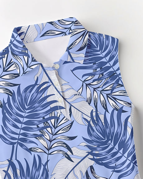 Blue and white tropical print golf shirt with palm leaf design on a light background