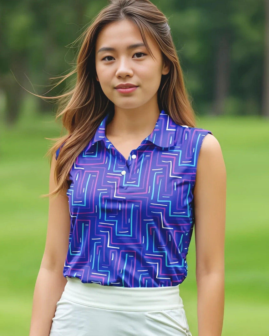 Woman wearing a blue geometric patterned sleeveless golf top on a green outdoor background