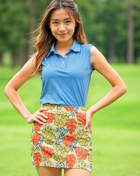Woman wearing a blue sleeveless top and colorful patterned skirt on a grassy background