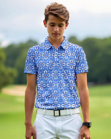 Young boy wearing a blue patterned golf shirt on a golf course