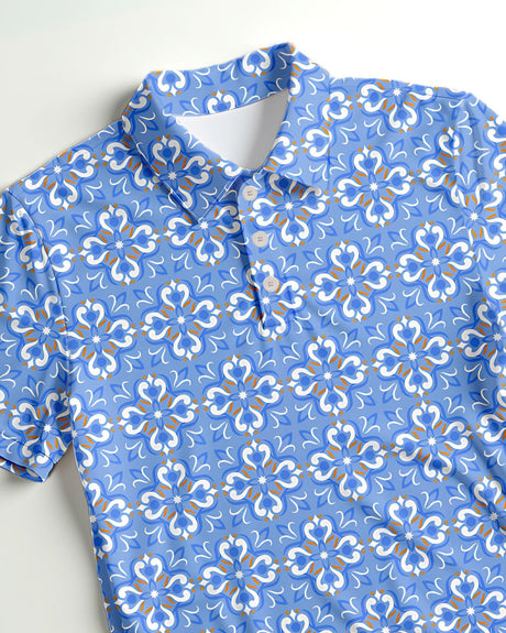 Blue floral patterned polo shirt for kids on a light gray background