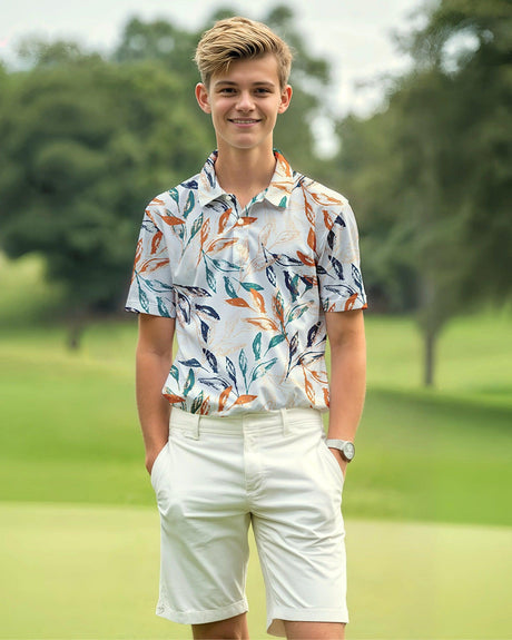 Young teenage boy in a floral polo shirt and white shorts standing on a golf course.
