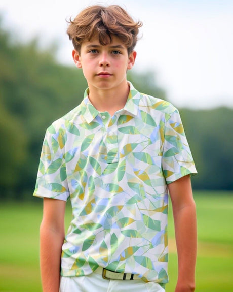 A young boy models a leaf-patterned golf polo shirt on a golf course.