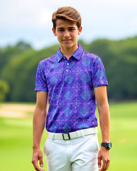 A smiling young man stands on a golf course wearing a patterned purple golf polo, white shorts, and a white belt.