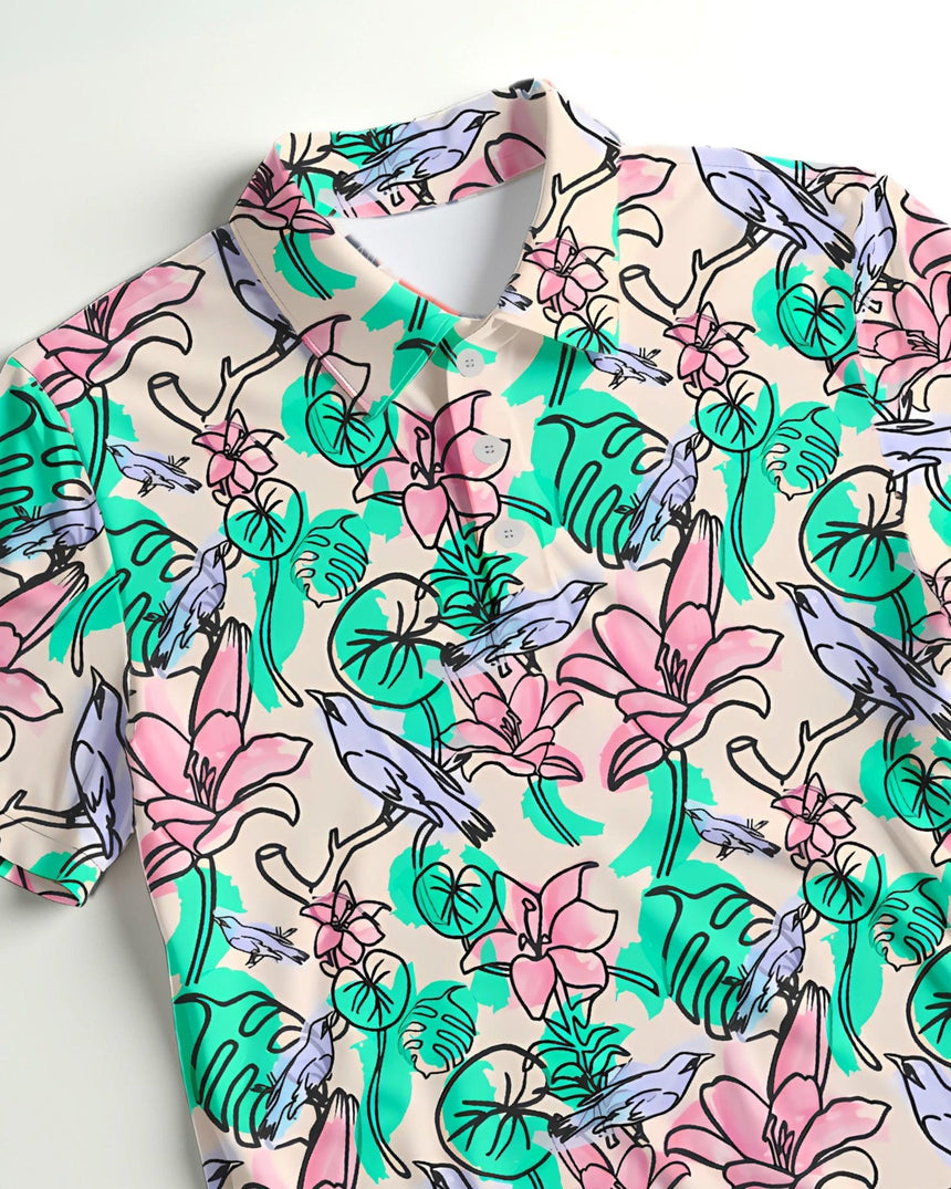 Close up of a short sleeve golf polo shirt with colorful floral and bird pattern on a light background