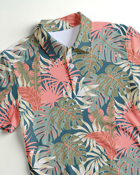 Close up of a green and pink tropical print polo shirt