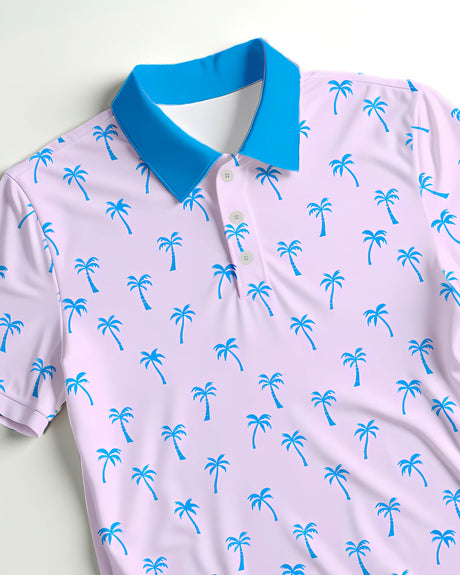 Close up of a pink golf polo with blue palm tree pattern and blue collar