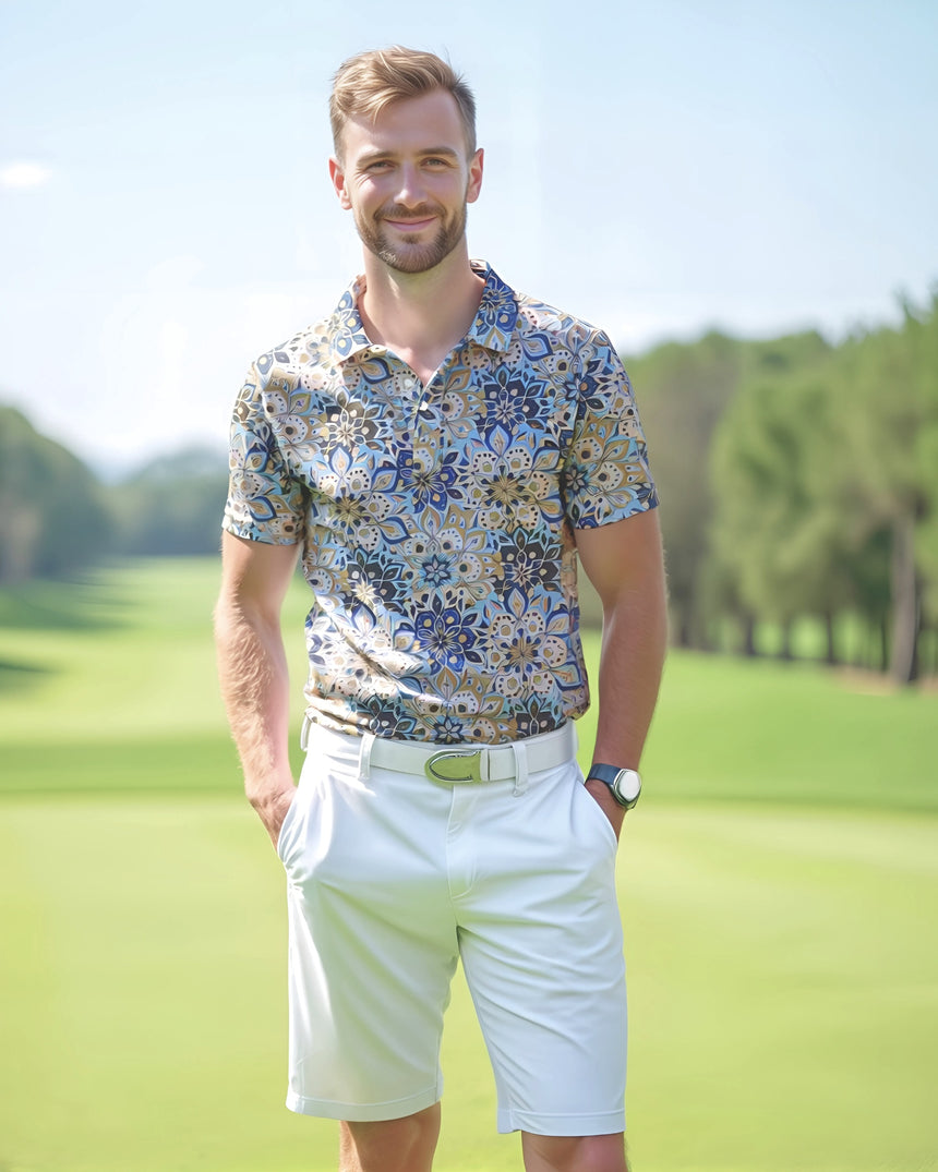 Man standing on a golf course wearing a blue and brown geometric floral print golf shirt polo and white shorts