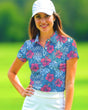 Woman wearing a colorful floral polo shirt and white cap on a golf course