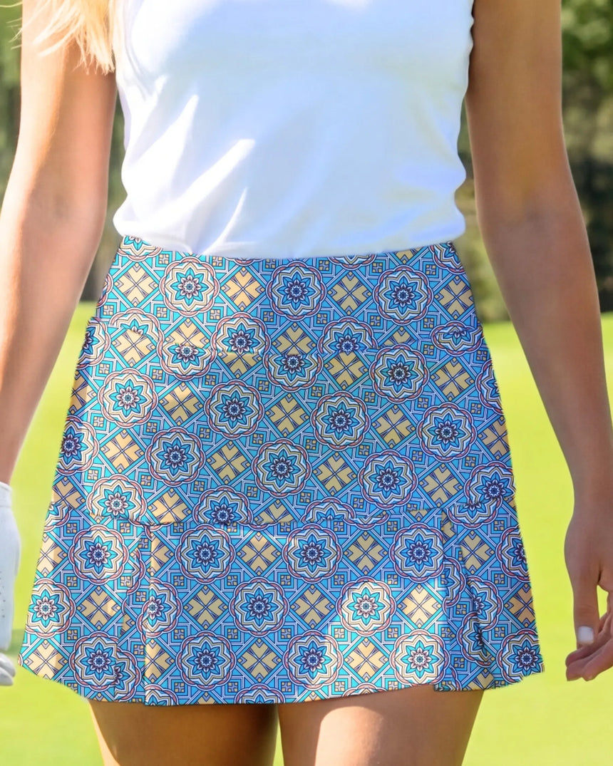 women's pleated golf skort with pockets in Sunset Swing print - model wearing on course