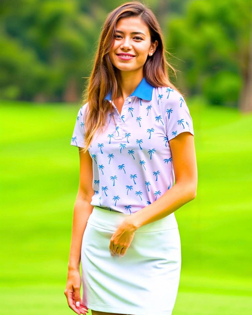 women's short sleeve golf polo in Palm Tree Pink print - model wearing on course