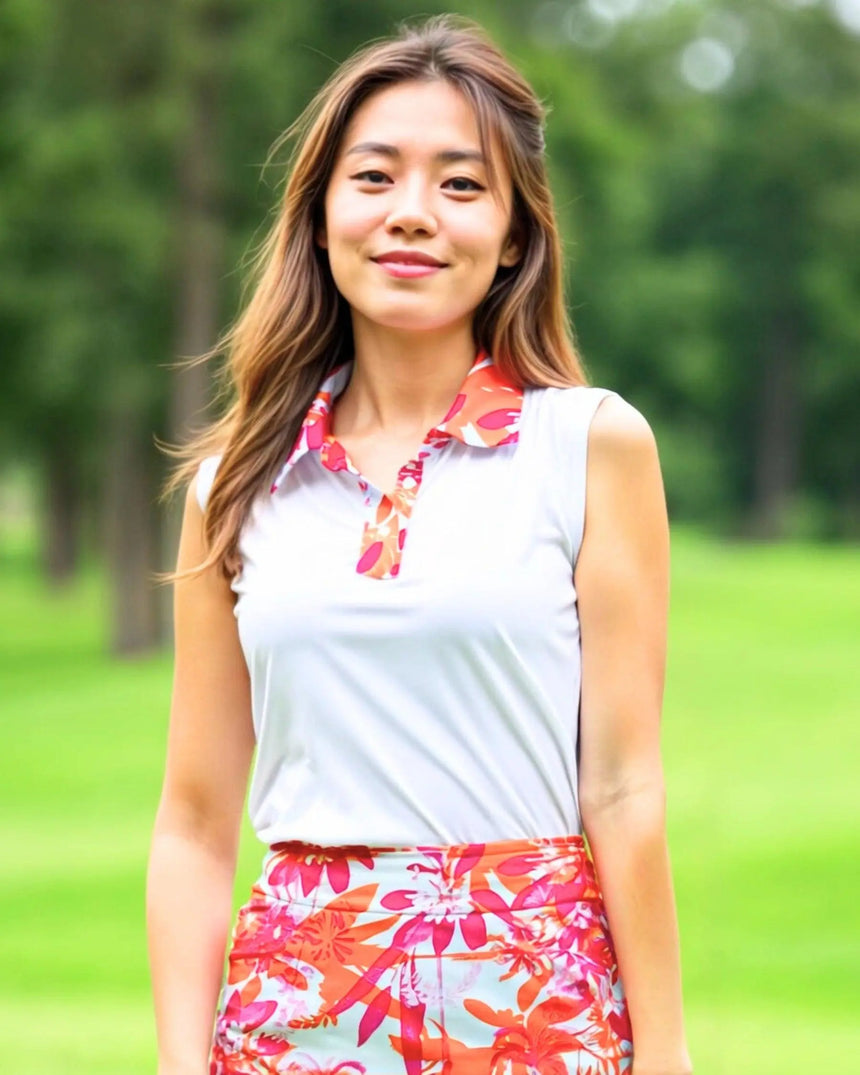 women's sleeveless golf polo in Hot Tropic print - model wearing on course