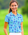 Woman wearing a blue patterned golf shirt on a green outdoor background