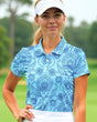 Woman wearing a blue patterned polo shirt on a golf course
