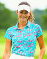 Woman on a golf course wearing a blue and pink flamingo pattern golf polo shirt