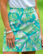 Green and blue patterned skort worn by a person with a blurred green background