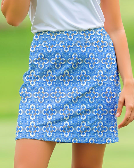 Blue floral patterned golf skirt worn by a woman with a green background