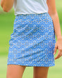 Blue floral patterned golf skirt worn by a woman with a green background