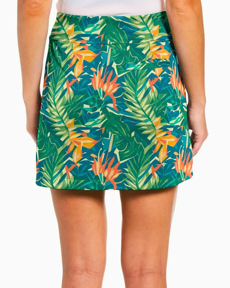 Tropical leaf patterned golf skirt worn by a girl on a white background