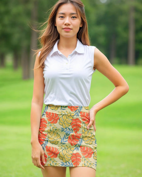 Woman wearing a white sleeveless top and colorful patterned skirt on a grassy background