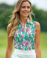 Woman wearing a colorful floral sleeveless polo shirt with a blurred green background