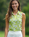 Woman wearing a green floral sleeveless golf polo with a blurred green background
