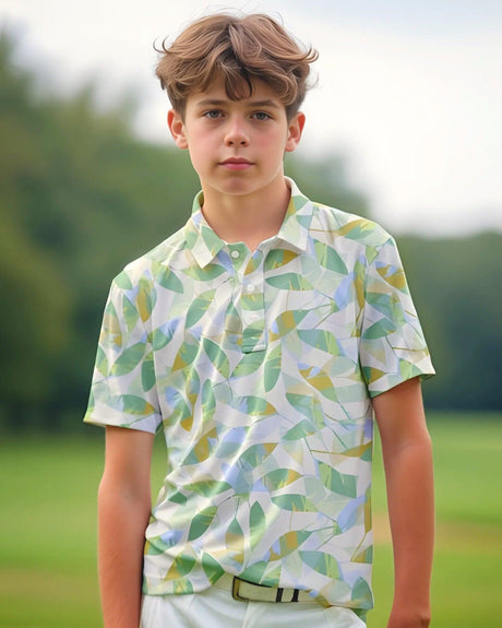 Young boy wearing a patterned golf shirt standing outdoors with greenery in the background