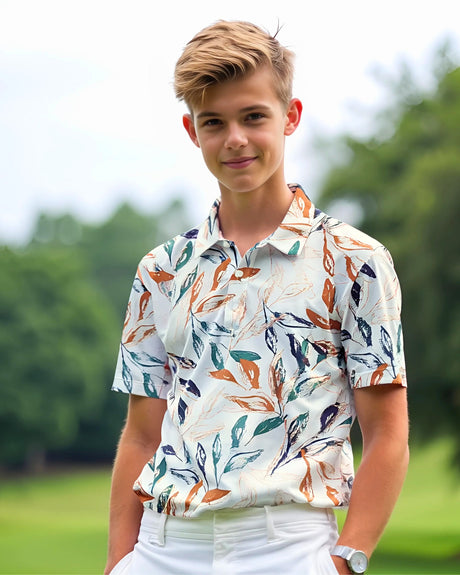 Young boy wearing a patterned golf shirt outdoors with greenery in the background