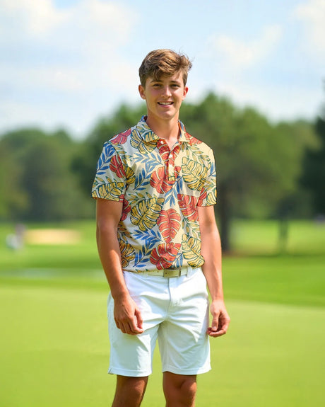Man wearing a colorful shirt and white shorts standing on a golf course