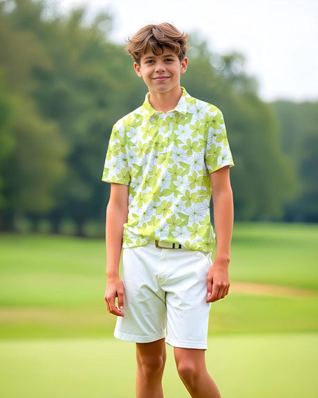 Teenage boy in a green and white floral polo shirt and white shorts standing on a golf course.